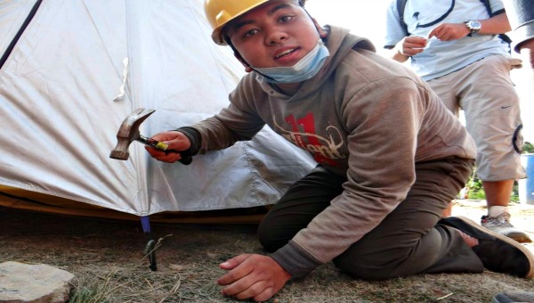 Nepal guy pitching shelter 600x340