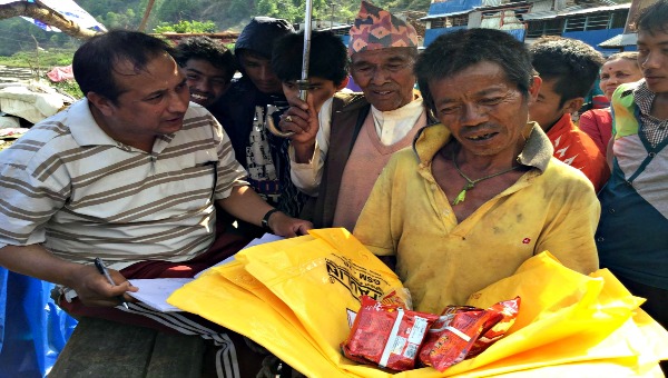 Nepal worker giving out supplies 600x340