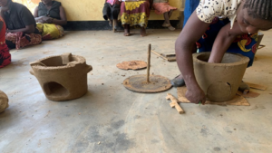 woman making stove pot from clay