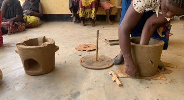 woman making a clay stove pot by hand