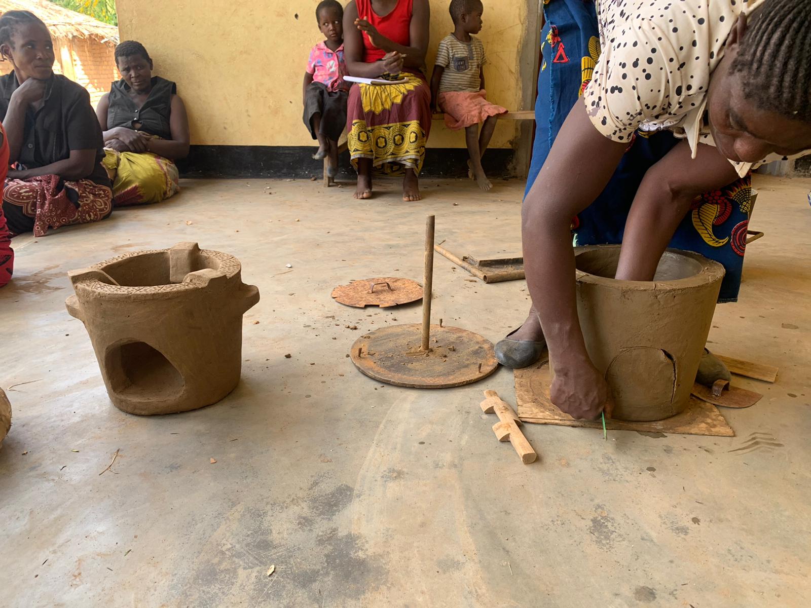 woman making a clay stove pot by hand