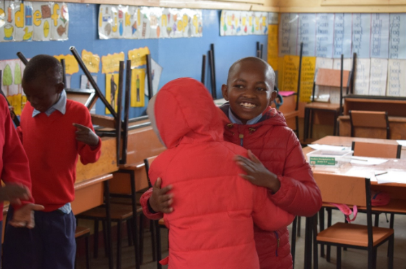 Children from Upendo programme hug in the classroom