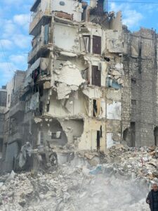 collapsed apartment block in Aleppo. 