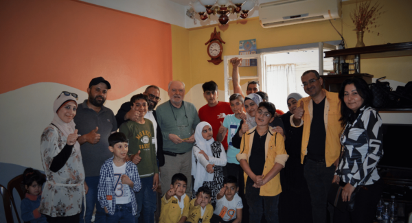 John poses with families in Lebanon