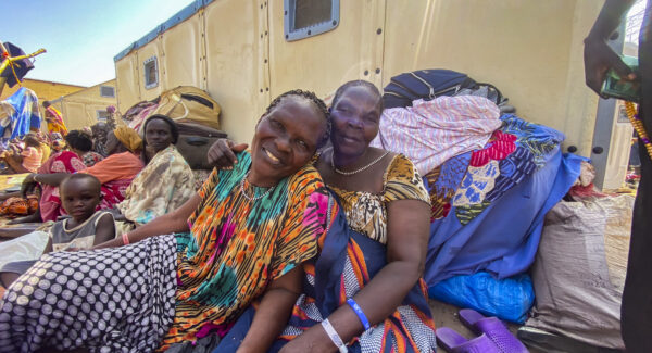 Catherine and Santuki pose for photo outside aid distribution station.