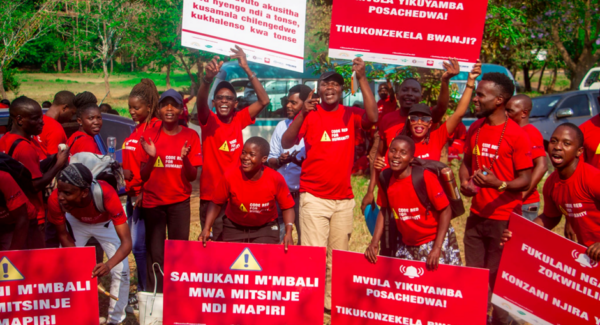 Climate activists at Code Red for Humanity rally post in red t-shirts and red posters calling for environmental policy