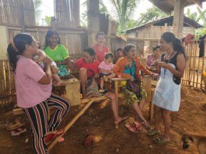 Pulangiyen women with children socialize under shelter.