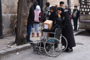 A woman in a wheelchair queues for food distribution in Aleppo.