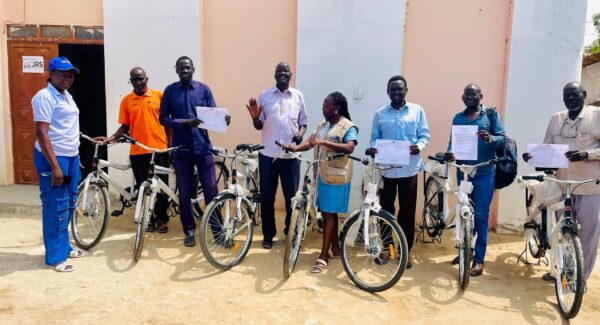 Teachers in training pose with certificates and bicycles helping their commute to schools and work