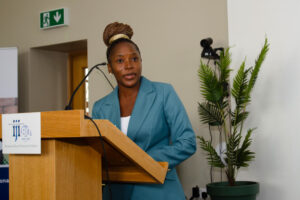 Martha stands at podium during her speech at IJI 80th conference 