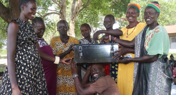 Fr Eric with MAJIS women farmers. The hold a safety deposit box which is building a community savings fund.