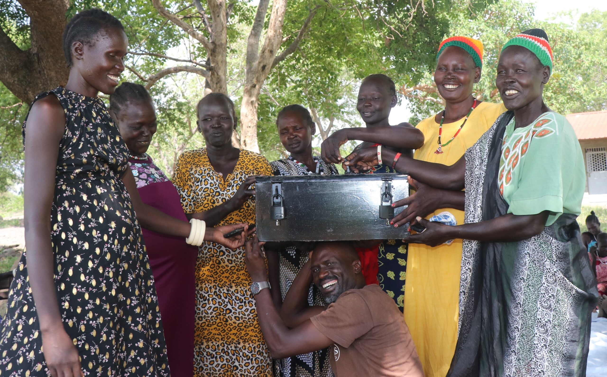 Fr Eric with MAJIS women farmers. The hold a safety deposit box which is building a community savings fund.