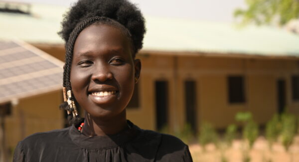 Athiei Dut Malual smiles standing outside her classroom in Rumbek, South Sudan.