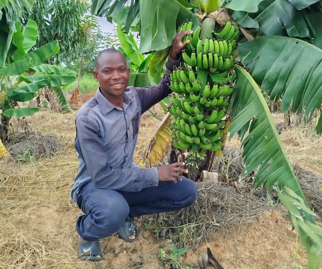 Happy, a famer in Malawi , poses at his banana plantation. 