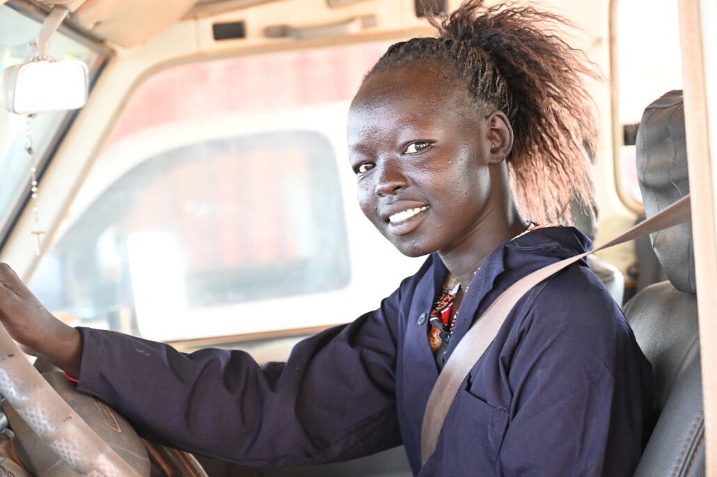 Martha sits at the wheel of a van