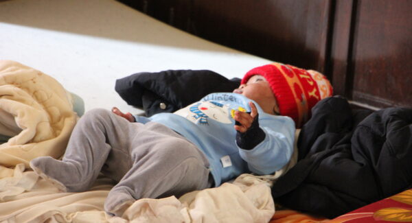 A baby sleeps on a mattress on the floor as families take shelter in St Joseph's Church in Beirut