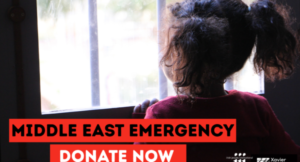 Girl in Lebanon looks out from the window at an emergency shelter
